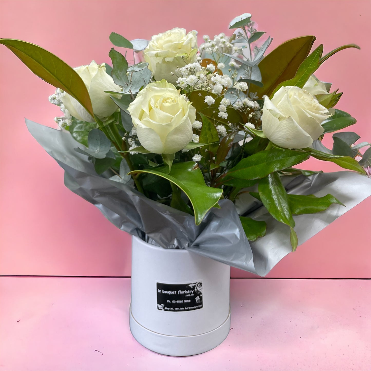 8 white roses in Cuddle Bucket arrangement
